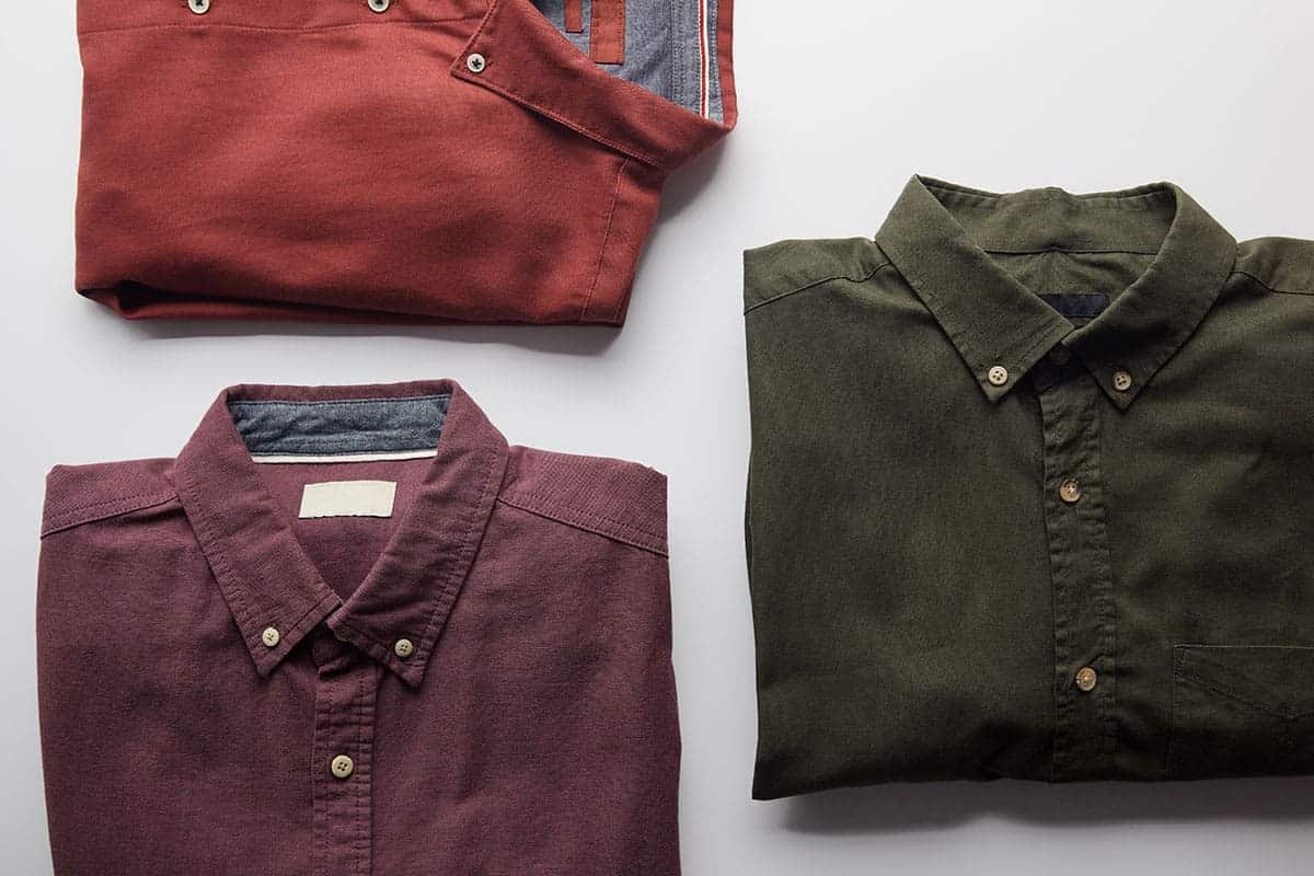 Three folded shirts in various colors, showcasing New Braunfels custom shirts.